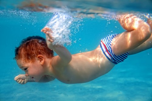 Dítě se potápí v bazénu