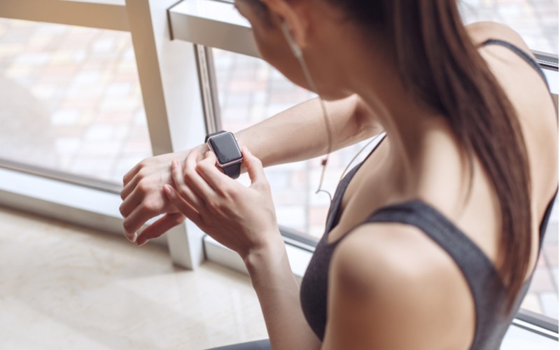mladá žena si sleduje čas na fitness hodinkách